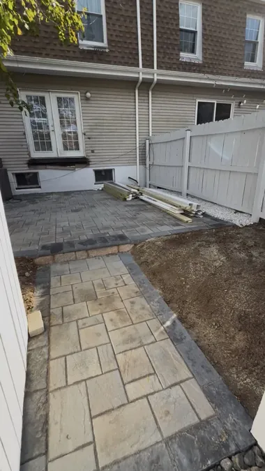 Flagstone patio between the fence lines