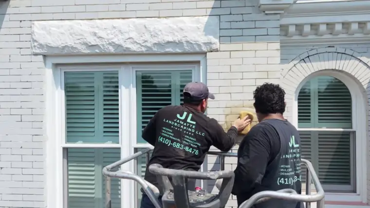 Two of the crew working from a lift on a rowhouse front